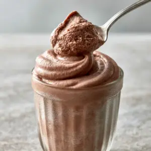 Close-up of semi-frozen chocolate frosty swirl with visible condensation on a ribbed tumbler. (Wendy's Frosty Slushie recipe)