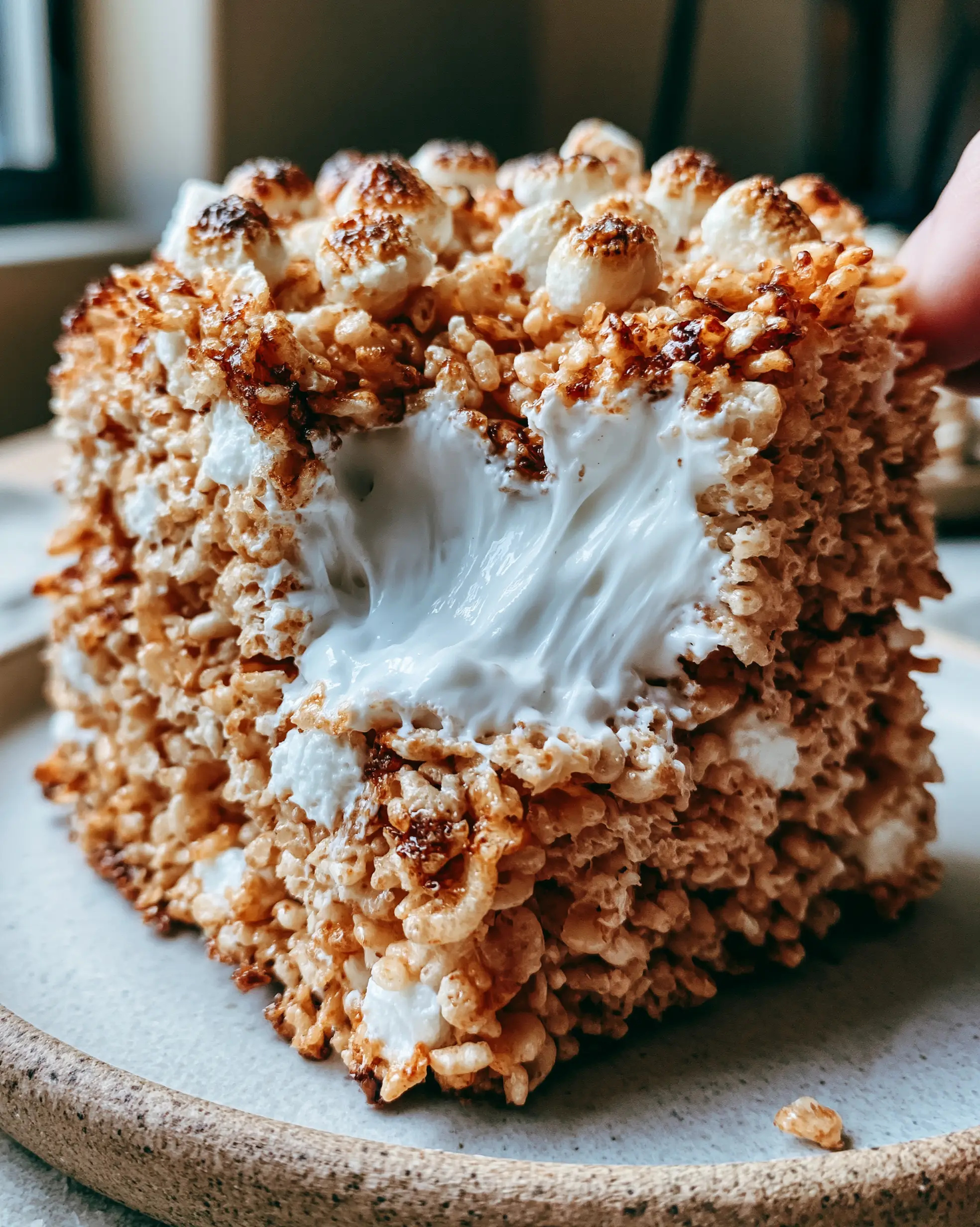Rice Krispie Treats Recipe: The Ultimate Brown Butter and Gooey Marshmallow Masterpiece 4 Close-up handheld photo of thick rice krispie treats with golden-brown edges and visible dark brown butter specks. (rice krispie treats recipe)