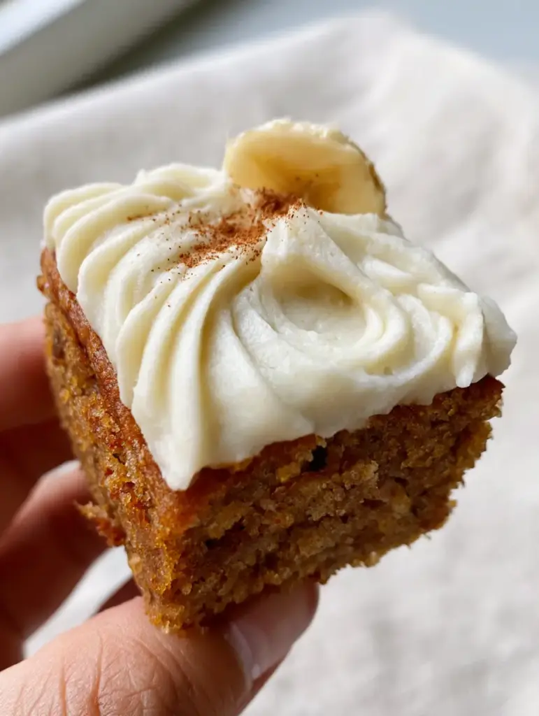 Close-up of the spatula swirls on a thick banana bar with a dusting of cinnamon.